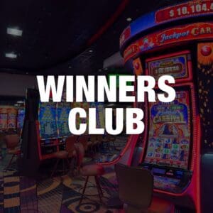 A casino's Winners Club area with slot machines and neon lights.