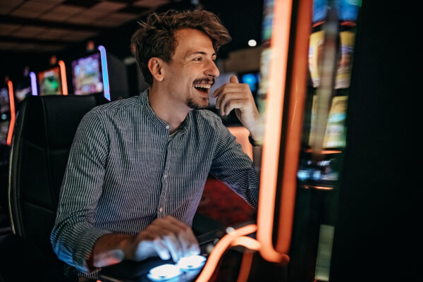Men gambling in casino on slot machinery