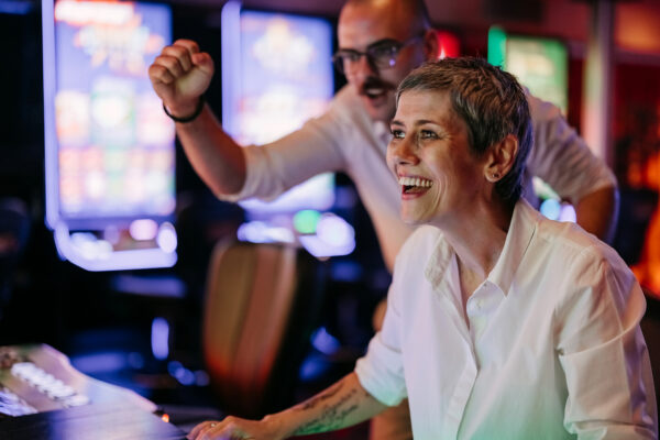 Two friends gambling on slot machine at the casino