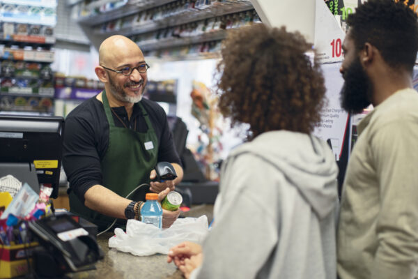 A young couple shopping in a small convenience store.