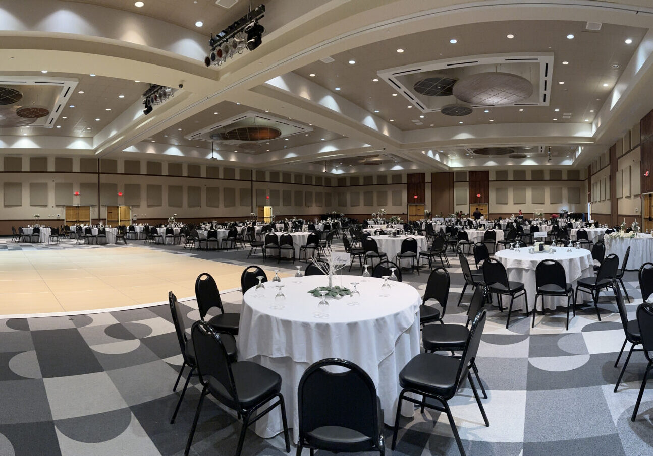 A large ballroom with tables and chairs.